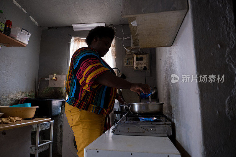 非洲妇女在煤气灶上做饭