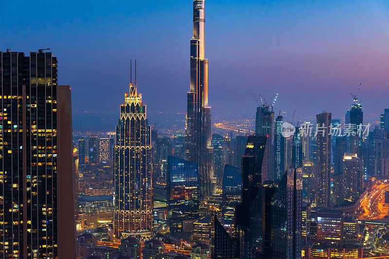 日落在迪拜市中心现代摩天大楼与哈利法塔