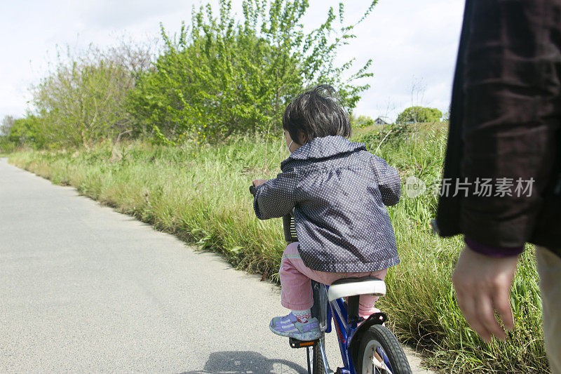 小女孩和爸爸一起骑车