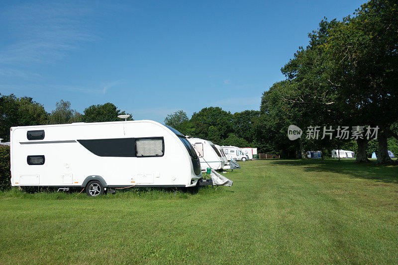 在阳光明媚的夏日，英格兰乡村的大篷车上的一排排大篷车和露营公园是Covid大流行期间完美的居家度假场所。