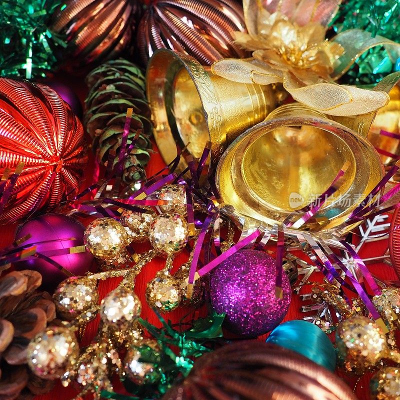 圣诞背景有圣诞装饰品、节日球、铃铛、蝴蝶结、冷杉锥、圣诞树雨。新年快乐，圣诞快乐。红色，棕色，条纹，绿色，金色，紫色，五颜六色的装饰