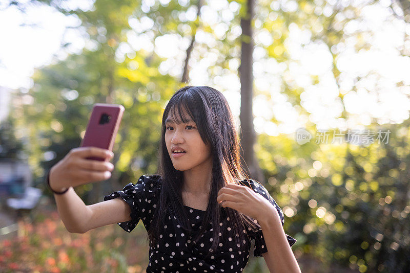 日落时分，一名少女在公园里自拍