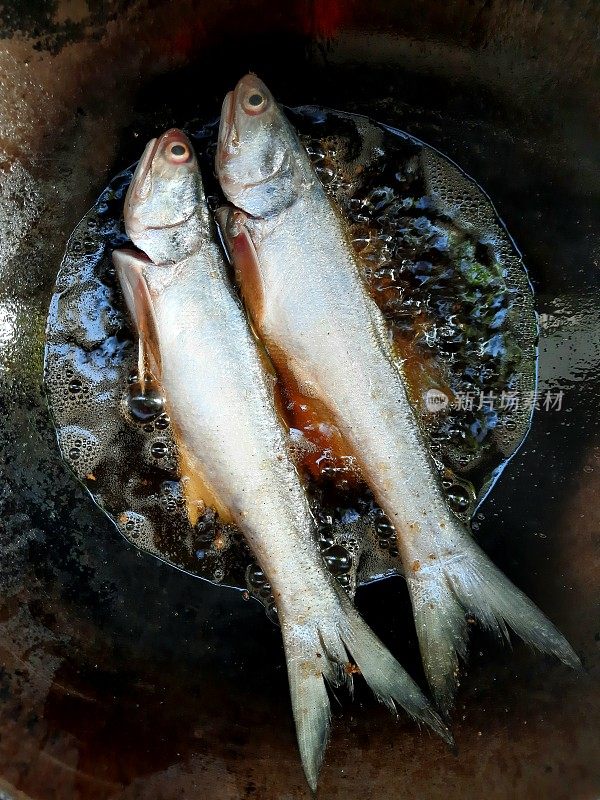 在平底锅里煎丝鳍鱼。