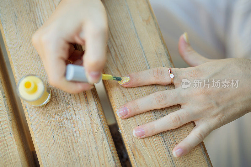 女孩在涂黄色指甲油