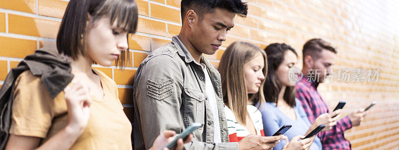 大学校园后院，多文化人群使用智能手机的水平横幅或标题。沉迷于智能手机的朋友。始终与学生保持联系的技术概念