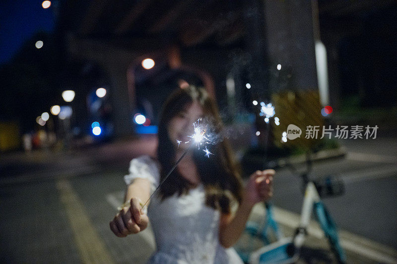 亚洲女孩在晚上燃放烟花