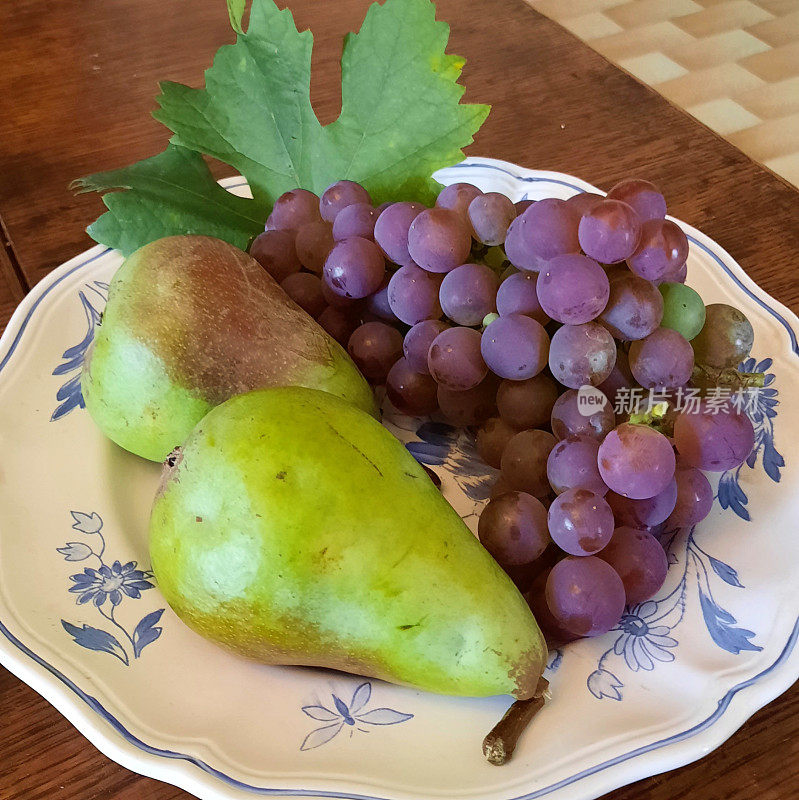 梨和葡萄放在瓷盘上
