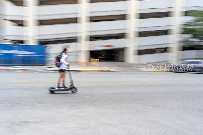 年轻女子骑着电动滑板车飞驰而过