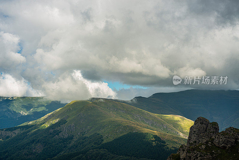 在一个阳光明媚的夏日里，有美丽的山峦和岩石景观。