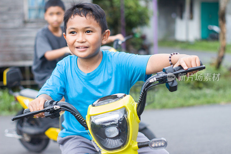 男孩和弟弟在小区骑着电动车，一起出去玩