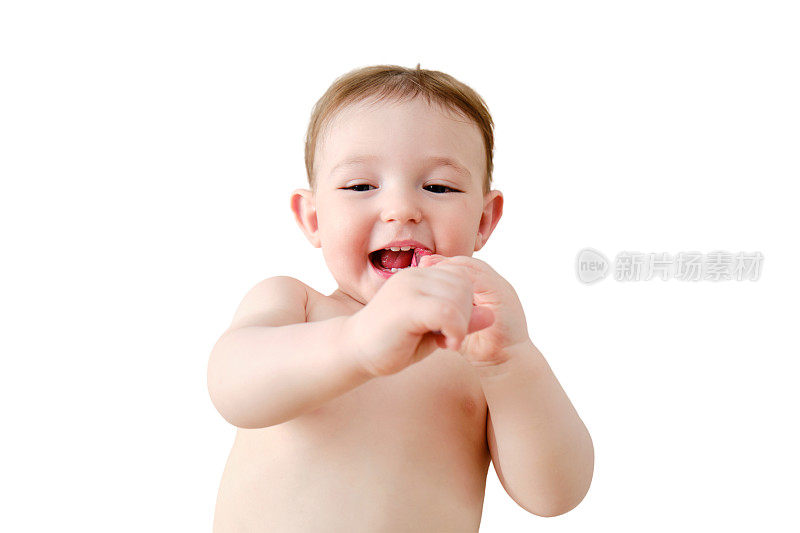 孩子在白色背景上用牙刷刷牙。快乐的学步婴儿躺在家里的床上学着刷牙。一岁儿童