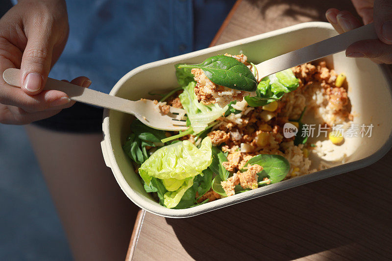 一名妇女正在享受一顿健康的素食午餐。美味均衡的食物概念。生态零废餐具。食品外卖