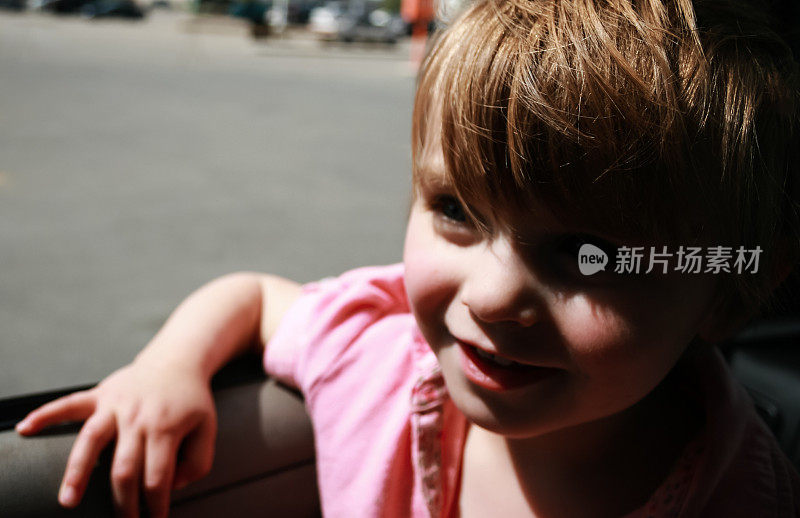 年轻女孩在阳光下的一辆车里的复古照片
