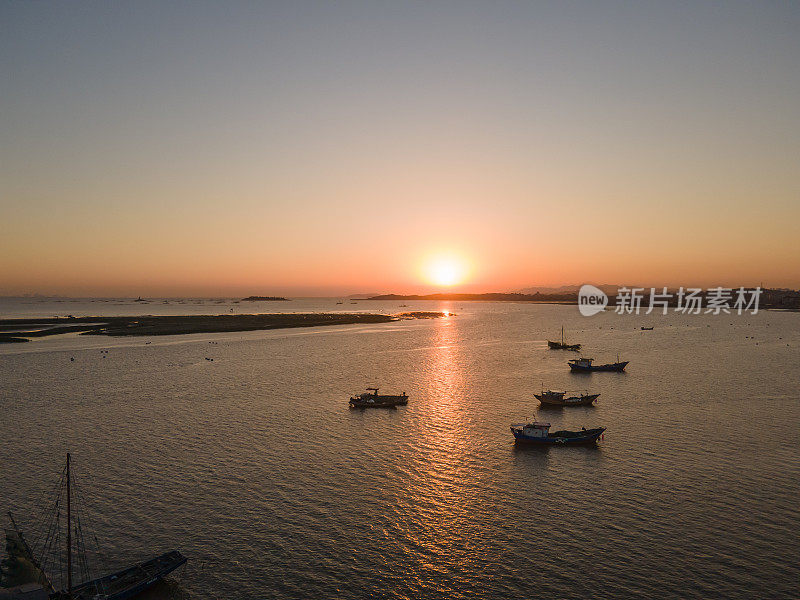 日出时，渔船停靠在海上