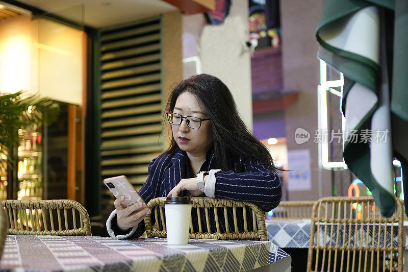 女游客坐在座位上，用手机点餐