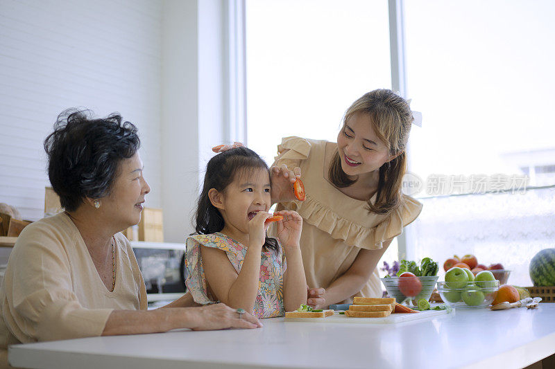 奶奶、妈妈和孙女在厨房准备食物。