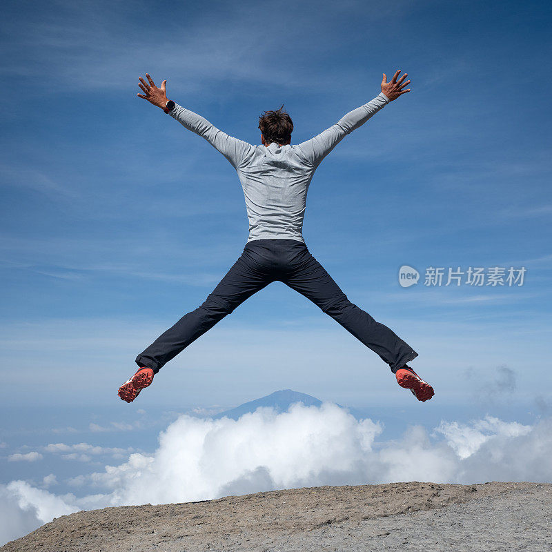 徒步旅行者从乞力马扎罗山的最高点跳下来，俯瞰梅鲁山