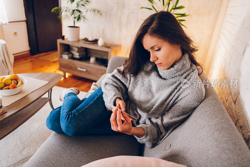 一位年轻女子用手机发短信