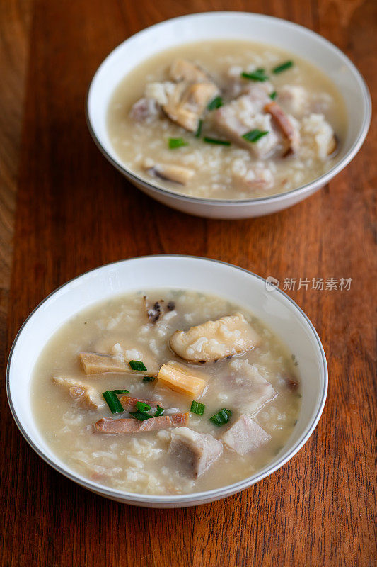 传统的中国食物——美味的海鲜和鸡汤粥，装在古董骨瓷碗里