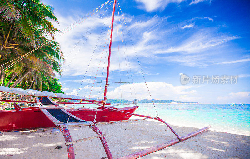 长滩岛白色沙滩上的一艘菲律宾红船