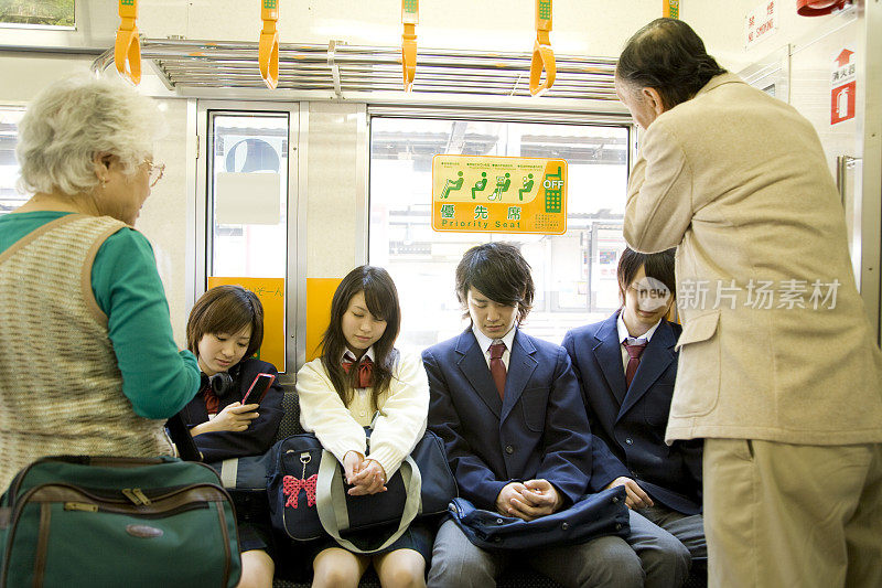 高中生坐在火车的优先座位上