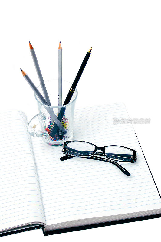 眼镜，钢笔，铅笔和夹子在笔记本上