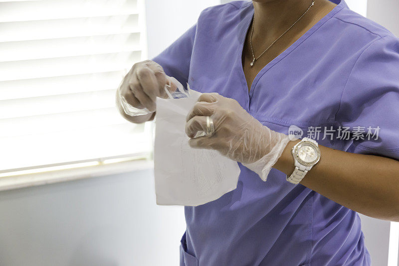 系列:家庭护理女护士戴着手套，手里拿着输液箱