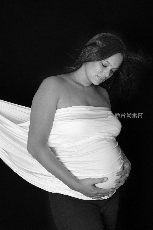 黑色和白色:孕妇的肚子上盖着毯子