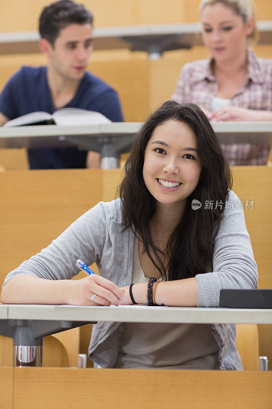 在报告厅微笑的学生