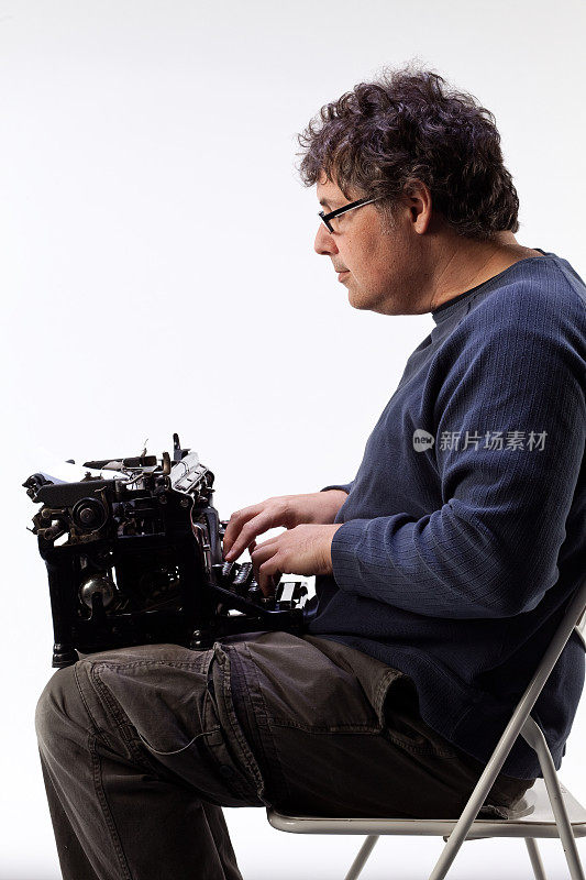 膝盖上放着一台打字机的男人。