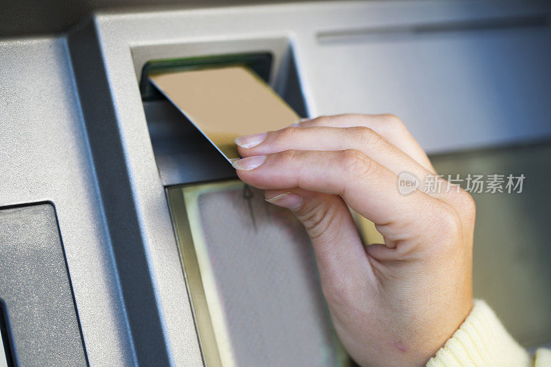 女人将信用卡放入自动取款机的手