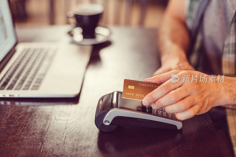 一名男子在咖啡馆进行非接触式信用卡支付
