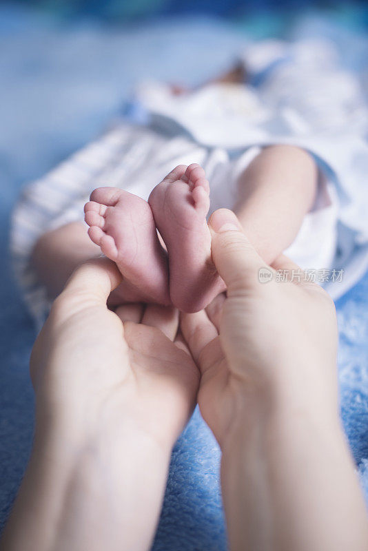 妈妈双手抱着宝宝的脚特写，温柔的时刻