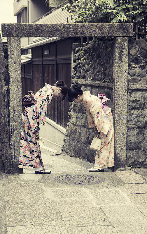 在日本京都，女孩们穿着传统和服互相敬礼
