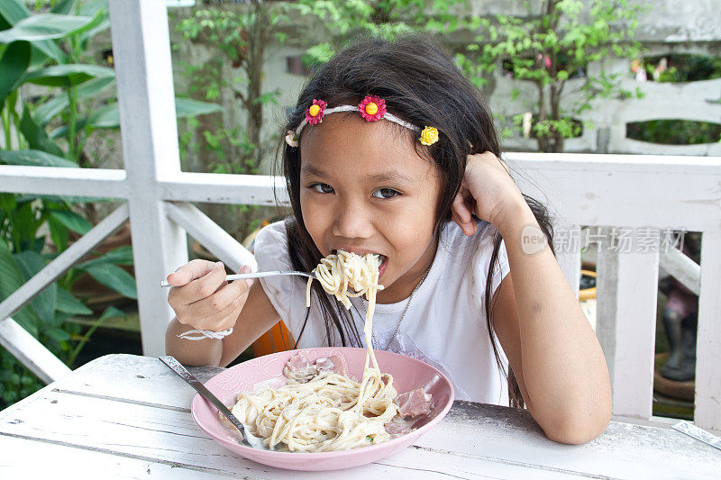 女孩吃意大利面。