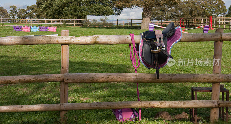 围场围栏上的粉色骑马装备