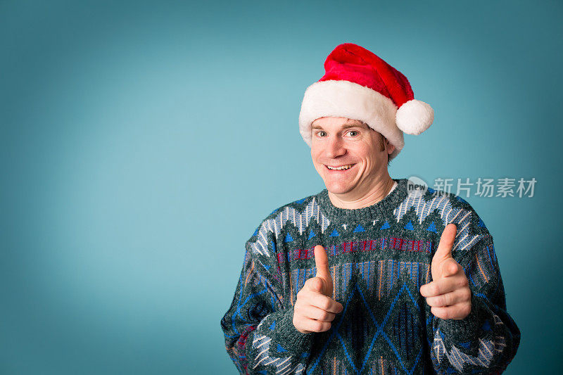 戴着圣诞帽和丑陋毛衣的兴奋表情的男人