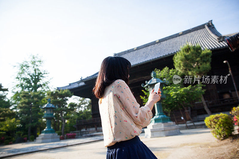 一名年轻的日本女游客正在使用手机