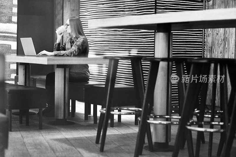 在咖啡馆用笔记本电脑工作的女人