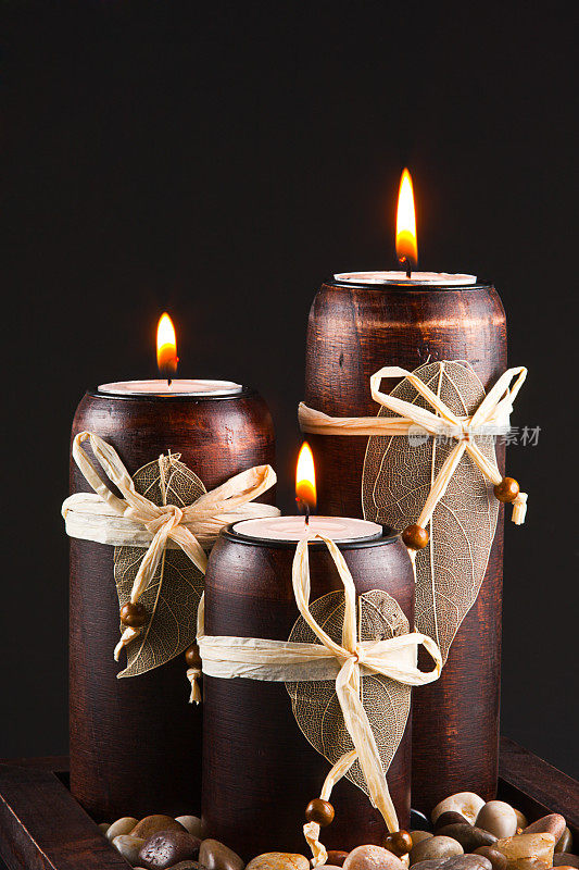 三支燃烧的蜡烛映衬着黑色的背景。
