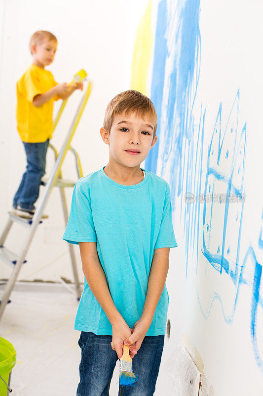 两个小男孩在刷墙