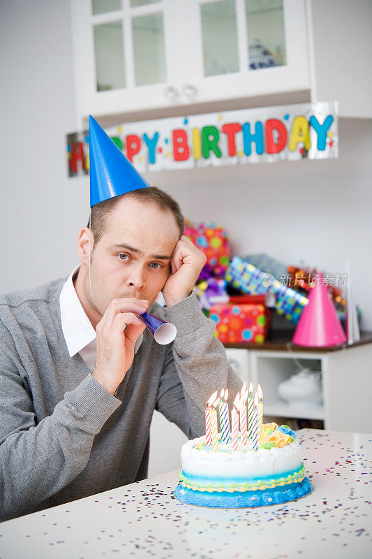 有蛋糕和蜡烛的伤心男人生日派对