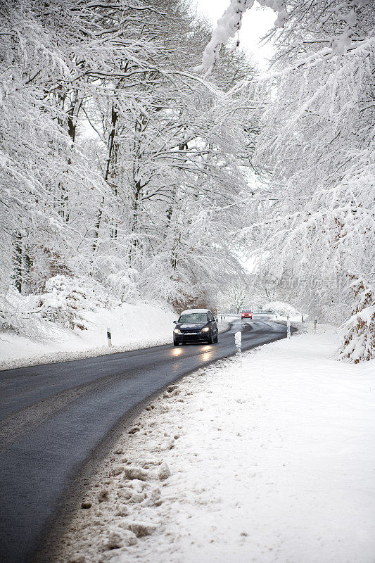 路上有两辆车在冬天的森林里白霜