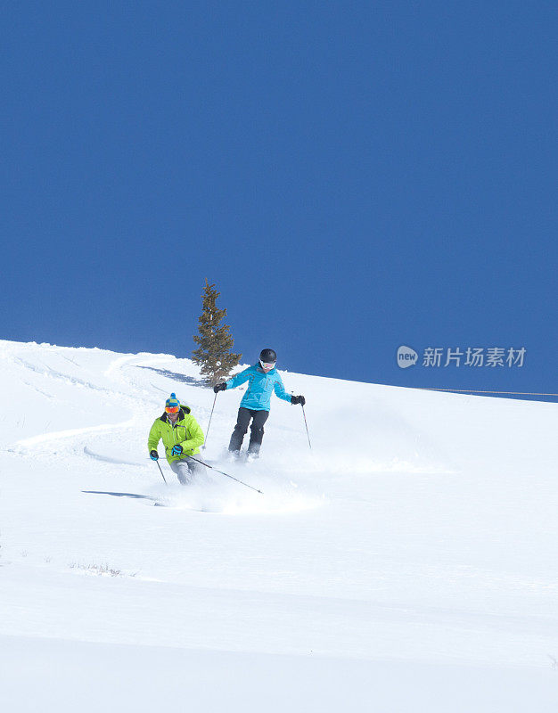 一对年轻夫妇一起滑雪粉，威尔，科罗拉多州。