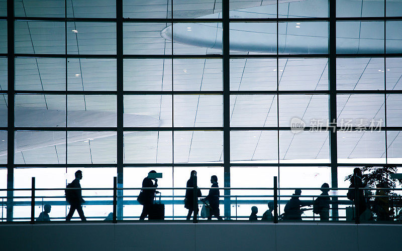 人们商务旅行，行走在现代机场