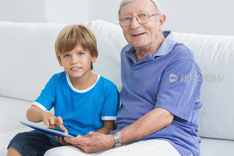 孙子和祖父在用平板电脑