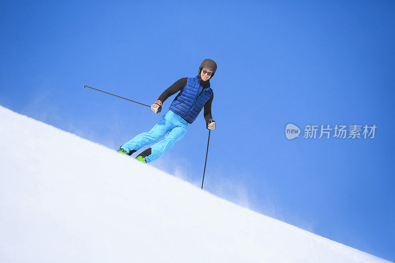 年轻人在阳光明媚的滑雪场滑雪