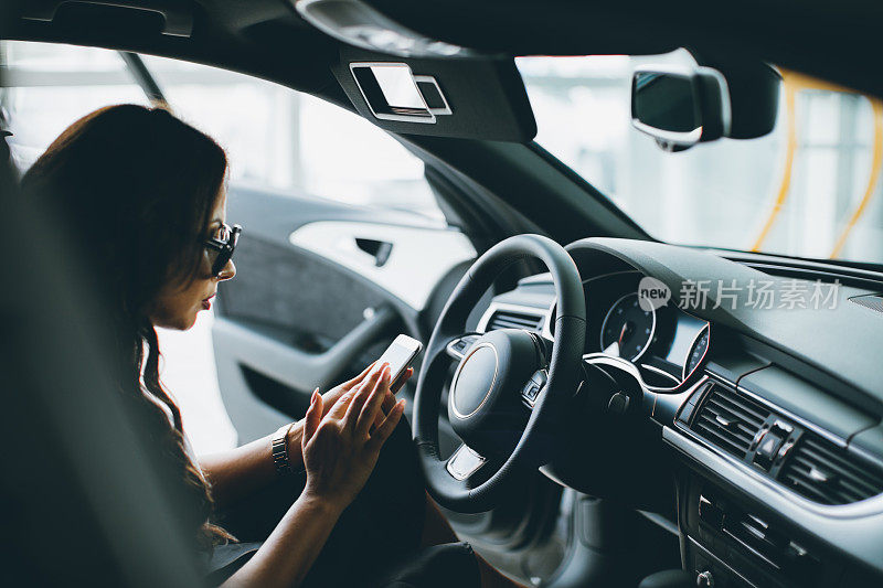 年轻漂亮的女人开着新车