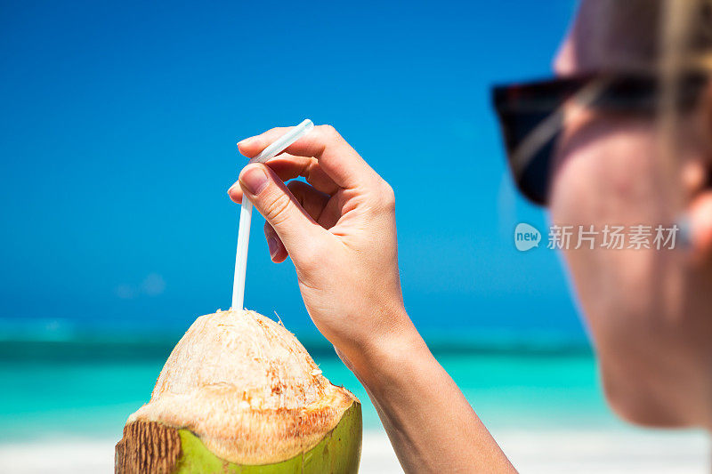 在海滩上喝椰子汁