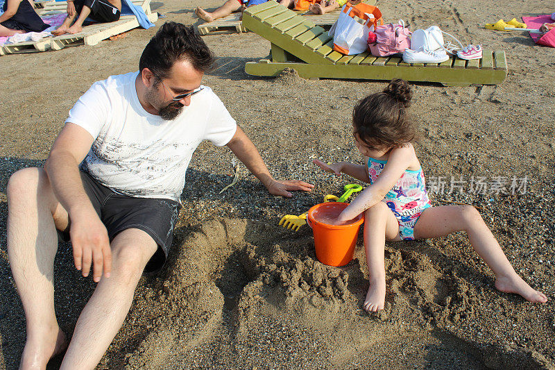 爸爸和小女孩在沙滩上玩耍